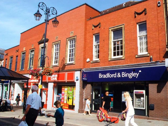 The 1938 Emporium of Morley Industrial Co-operative Society Ltd. on Queen Street has now been broken up into individual shops. Those visible in this picture include the Bradford and Bingley Building Society and Thomas Cook travel agents.