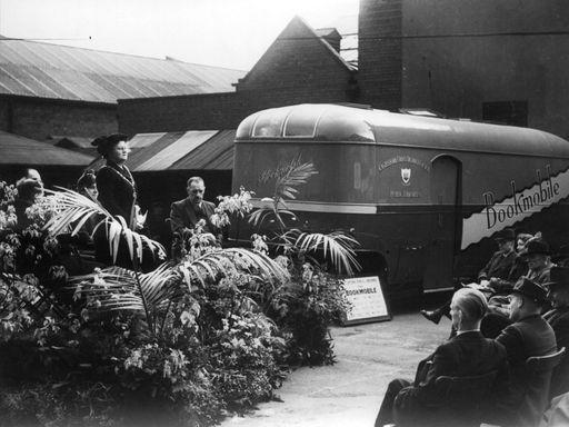 A photo of a converted bus parked alongside the library on the old outdoor market site