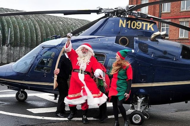 Father Christmas arrives by helicopter to his grotto in Botany Bay.