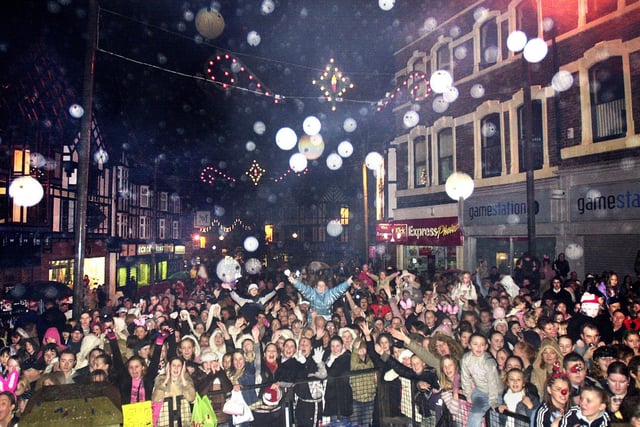 Around 7,000 people form an excited crowd in Wigan Market Place to watch McFly turn on the Christmas lights and perform on stage in 2004.