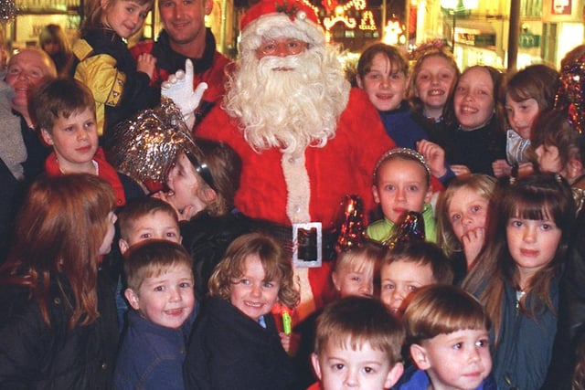 Santa surrounded by excited youngsters after switching on the Christmas lights in Wigan town centre in 1999.