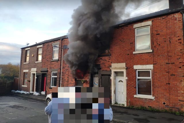 Worried neighbours watch in horror as the home is consumed with fire moments after the family were rescued by neighbours who used a ladder to help them escape from an upstairs window