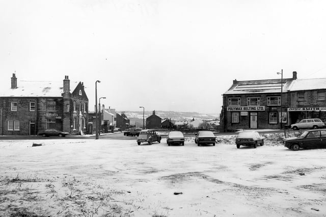 Looking across to Pudsey Lowtown at the junction with Hough Side Road in January 1982. On the left is the Victoria Hotel. To the right are Polymax Belting Ltd. and Charles Smith, greengrocer.