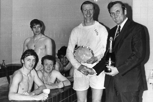 Don Revie presents Jack Charlton with a bottle of champagne and the Footballer of the Month trophy in the changing room after a match in 1972.
