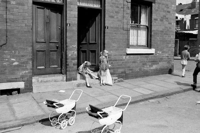 Children play in the street outside their Leeds home in 1969. Two little girls, perhaps sisters, are in the doorway of number 7 of an unknown street, possibly in the Hyde Park area.