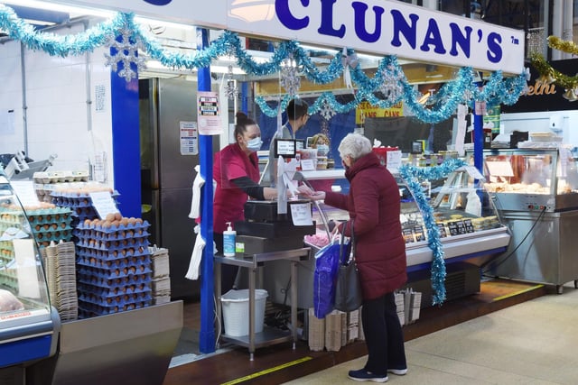 Wigan indoor market stall holders welcome customers.