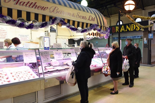 Customers queue at stalls at Wigan indoor market.