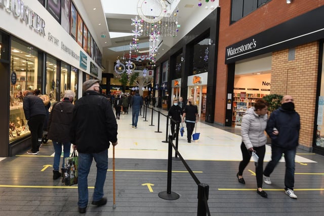 A steady stream of people entering in and out of The Grand Arcade shopping centre, Wigan.