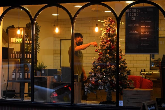 Adding the finishing touches to the tree at the Northern Barber Co.