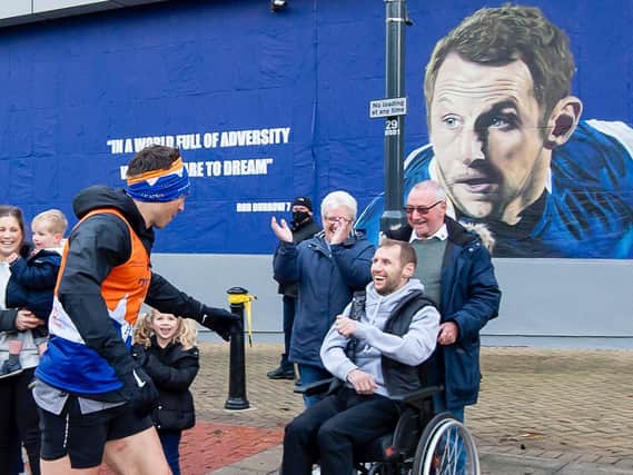 Rob Burrow greets Kevin Sinfield by the new mural painted in his honour on the side of Leeds Beckett University's Student Union in Woodhouse Lane.
