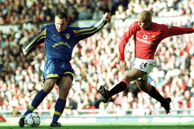 Mark Viduka pulls the trigger as Wes Brown comes in for the challenge.