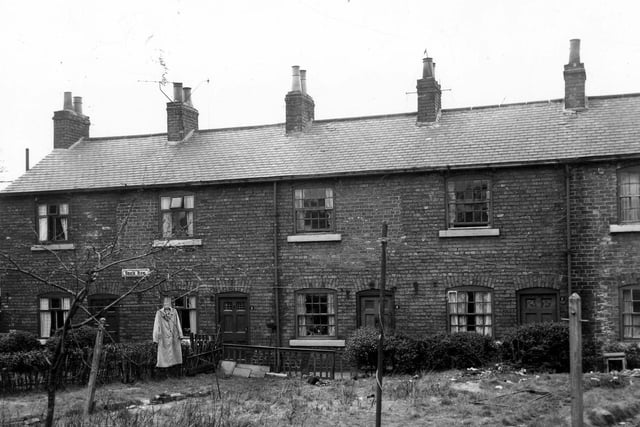 Houses on Brick Row pictured in March 1966. Properties have gardens to the front with back doors opening onto a small pathway to the rear. They were included in slum clearance plans for the Green Road area.