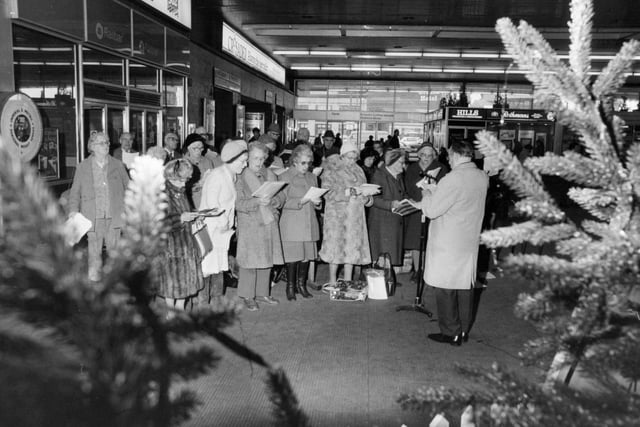Carol singing for the Leeds Council for Voluntary Services Christmas Appeal at Leeds City Station in 1982.