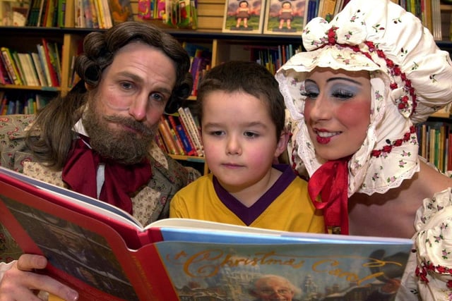 Mr and Mrs Fezziwig, two characters from the Northern B01allet Theatre production A Christmas Carol played by Christopher Hinton-Lewis (left) and Florence Bas read to James Duke at Borders bookstore in Leeds in 2001.