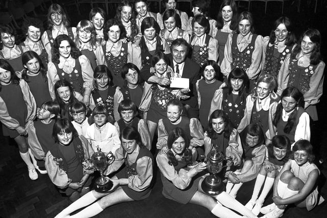 Woodford Youth Club morris dancing squad with their trophies and a donation to Dr Philip Silver cancer research fund in 1974