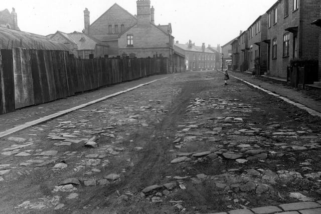 November 1953. View looking north-east along Hall Place. Children play on the road, which is unmade and stony.