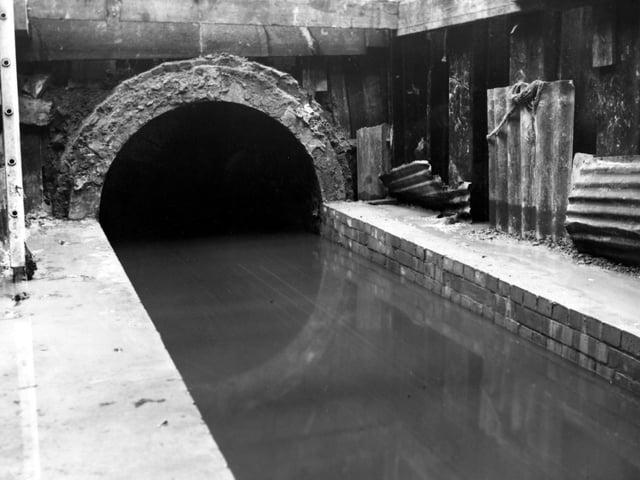 This photo from May 1950 shows the low level sewer on South Accommodation Road. Corrugated steel is visible to one side whilst a ladder can be seen on the other.