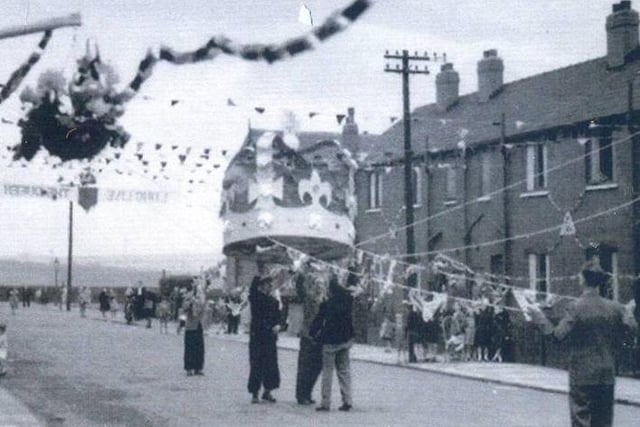 A large model of a crown being pulled into place during preparations for the celebrations for coronation of Queen Elizabeth II in June 1953. The view looks to the junction with Copperfield View.