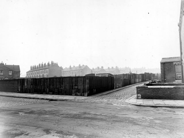 A view looking north along Back Cross Green Crescent from Cross Green Lane. Houses on the Fewston Estate can be seen on the other side of the railway line with the Glencoes in the far distance to the right. Pictured in November 1950.