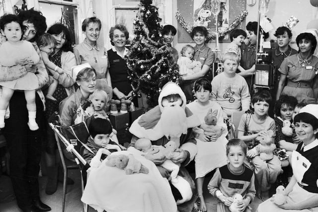 Father Christmas spreads some festive cheer at the children's ward at Wigan Infirmary, Christmas 1985.