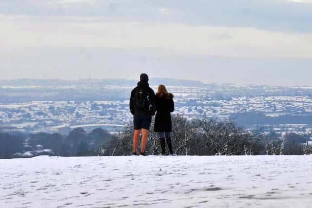 A couple admire the winter scene over Wigan outside Haigh Hall.