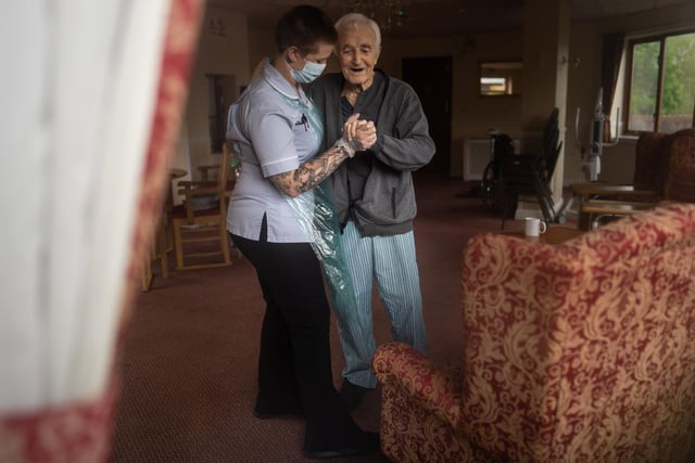Jack Dodsley, 79, dances with a carer in PPE at Newfield Nursing Home, Sheffield.