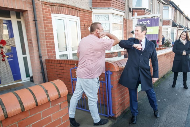 Labour leader Keir Starmer bumps elbows with a resident in Bentley, Doncaster, while on a visit meeting people affected by last year's floods