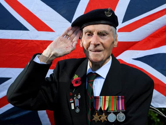 George Leslie Hall, 100, a former Prisoner of War putting out the flags for VE Day