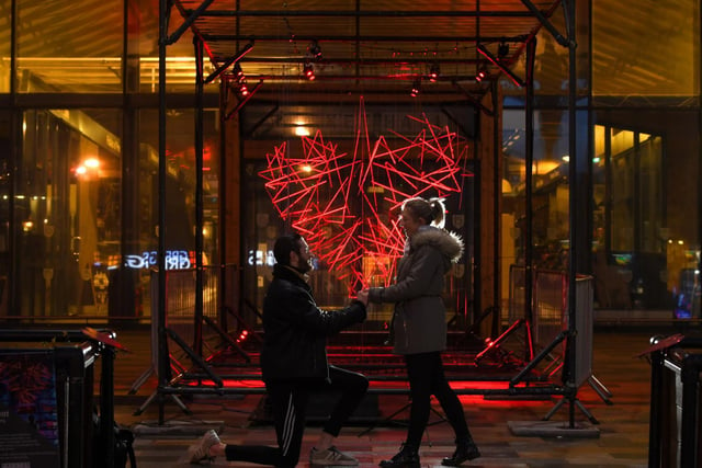Drew Noon and Anna Miller get romantic in front of the Heartbeat art installation at Preston Market