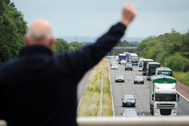 A convoy of coaches travel down the M55 to highlight their plight during the coronavirus crisis.  Coach driver Kjell Saele shows his support to the convoy.