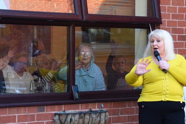MARCH - Local singer Pat Masterson entertains residents at Ambleside Bank care home, Ince, Wigan, from the car park during the coronavirus outbreak quarantine.  When the lockdown was new and there was so much uncertainty, it was lovely to capture moments like this, seeing the care home residents enjoying the music, singing and dancing through the window.