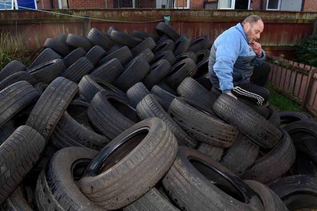 Neil Black with the 600 tyres that have dumped in his garden