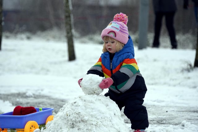 2-year-old Martha Reed building her snowman in Buckshaw Village