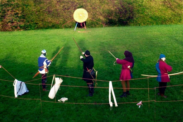 English archers practise their bowmanship at the castle.