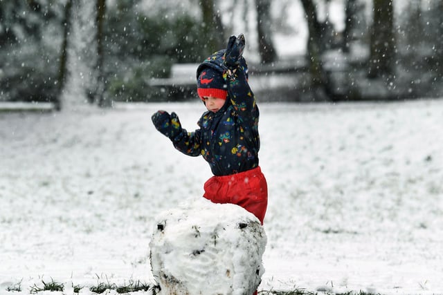 Three-year-old Winston Hallas builds a snowman in Pudsey Park