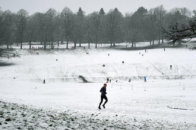 A runner braves the snow in Roundhay Park, Leeds