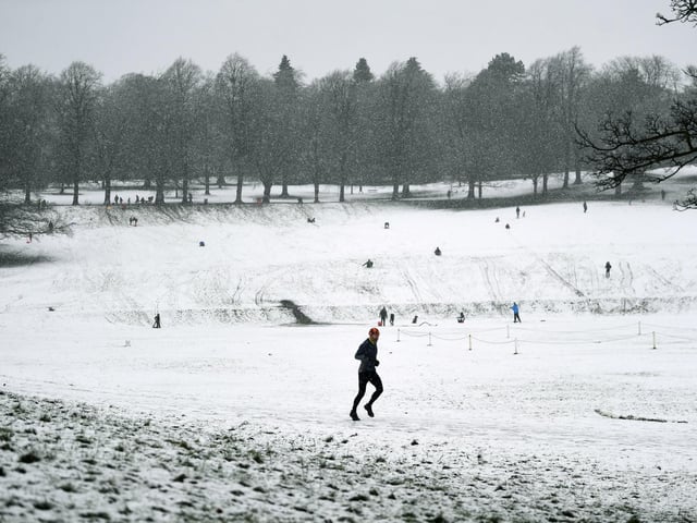 A runner braves the snow in Roundhay Park, Leeds