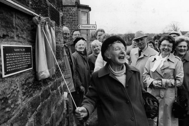 April 1986 and Vera Watson laughs with delight as she unveils a plaque - her gift to the community - which gives details of the historic Bar Tollhouse. Miss Watson retired as clerk to Scarcroft council in 1983 after 27 years.