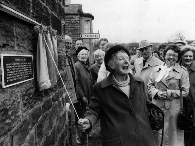 April 1986 and Vera Watson laughs with delight as she unveils a plaque - her gift to the community - which gives details of the historic Bar Tollhouse. Miss Watson retired as clerk to Scarcroft council in 1983 after 27 years.