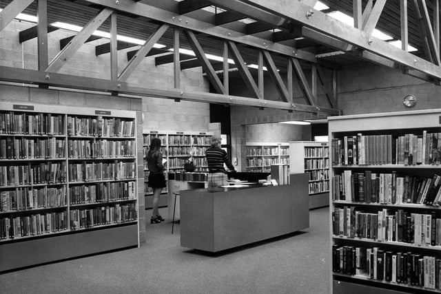 The counter is in the centre where two members of staff are working. The non-fiction books are shelved around the walls and free standing bookshelves display the adult fiction.