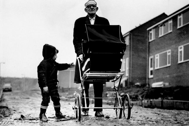 Andrew Ross takes his daughter's baby for an outing down muddy Wheelwright Avenue in Lower Wortley in 1969. With him is two-year-old Colin Glacken who lives in the avenue.