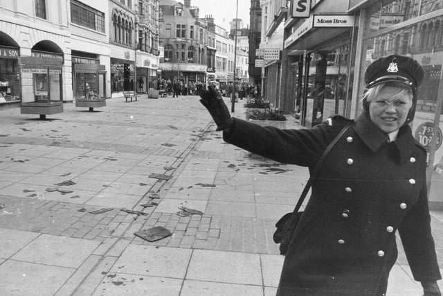 Slate-strewn Commercial Street was empty of shoppers in November 1973 after part of the pedestrian precinct was closed owing to stormy weather. Pictured is meter attendant Eleanor Greenwood