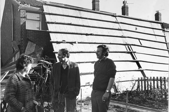 A complete roof, covering a block of eight garages in Bramley, was ripped off during gales in November 1973. Pictured discussing the issue are local residents 
Mr and Mrs P. Longbottom with Malcolm Henson.