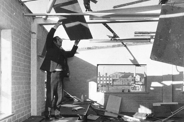 November 1973 and Roy George Hurley, managing director of George A. Hurley Ltd. dress manufacturers on Dewsbury Road looks at  the gale damaged roof of his premises.