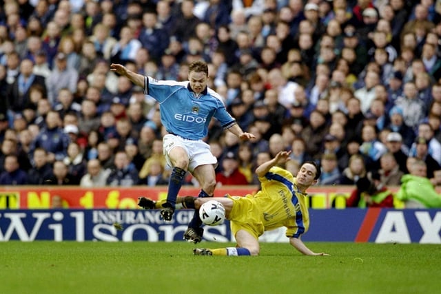 Manchester City striker Paul Dickov skips over the challenge of Gary Kelly.