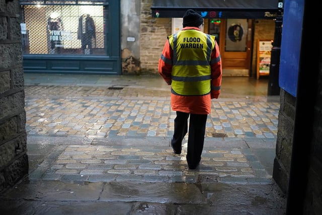Volunteer flood warden Keith Crabtree MBE patrols the streets as rain and recent melting snow begin to raise river levels in the Calder Valley