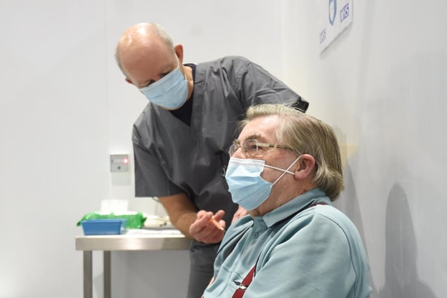 Volunteer vaccinator Stan Ralph gives the vaccine to 87-year-old Michael Doidge.