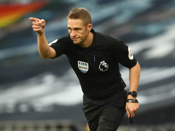 English referee Craig Pawson indicates a penalty after checking the touchline screen to study a foul during the English Premier League football match between Tottenham Hotspur and Leicester City.