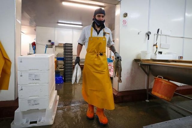 A member of staff at Midland Fish in Fleetwood carries fish prepared for sale