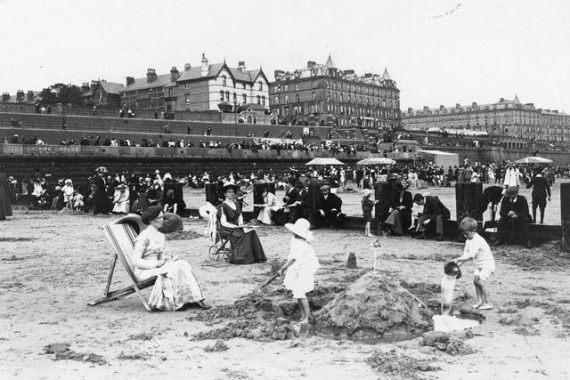 circa 1913: Building a sandcastle on the beach at Bridlington